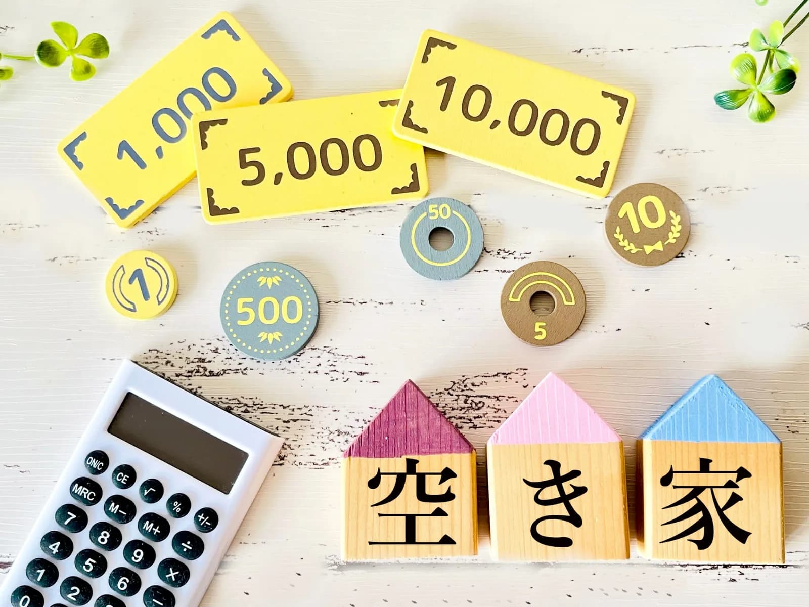 「空き家」の文字ブロックと電卓とお金のカード（空き家の処分費用に関する記事のイメージ）