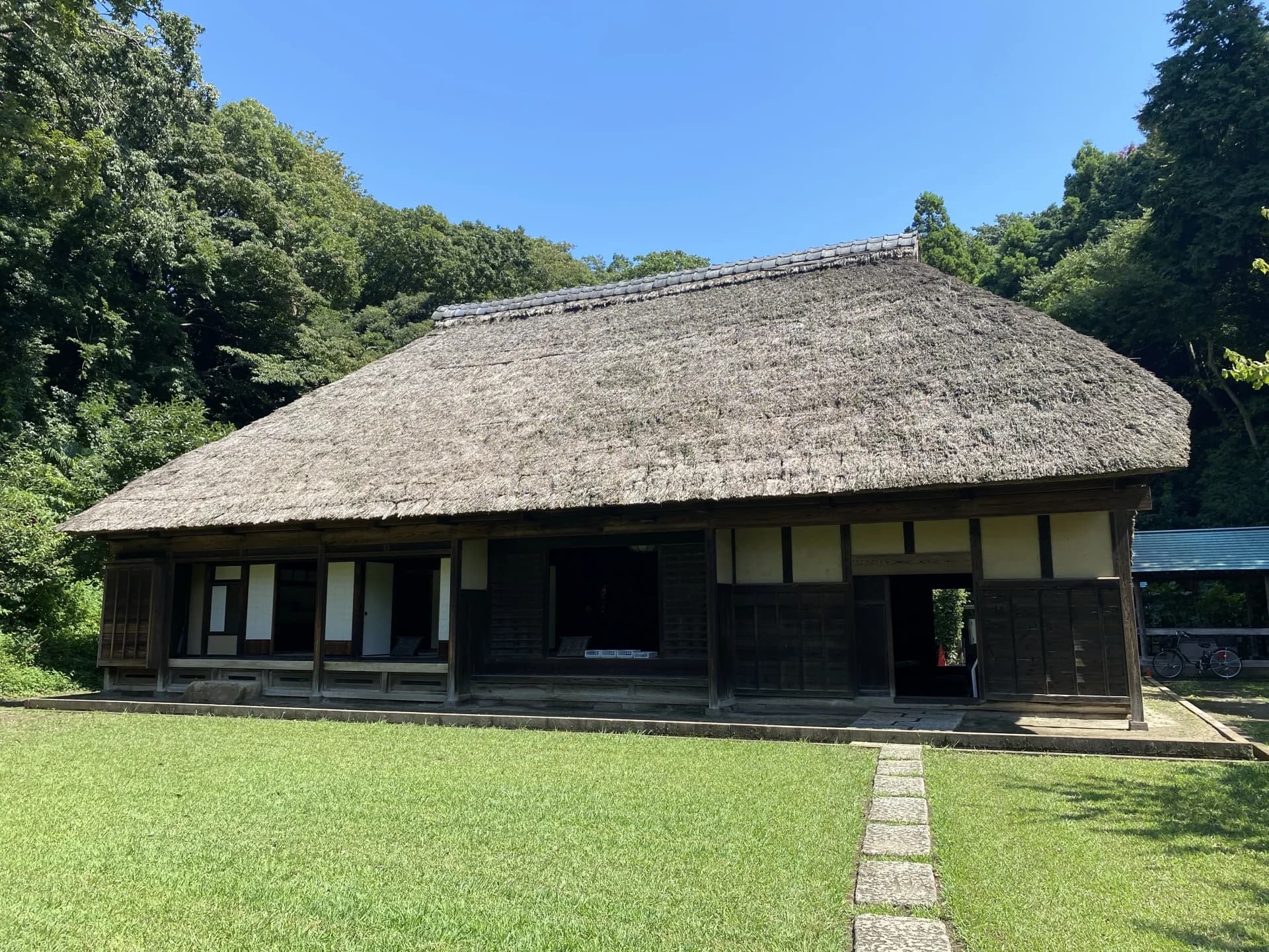 芝生の庭に建つ茅葺き屋根の古民家