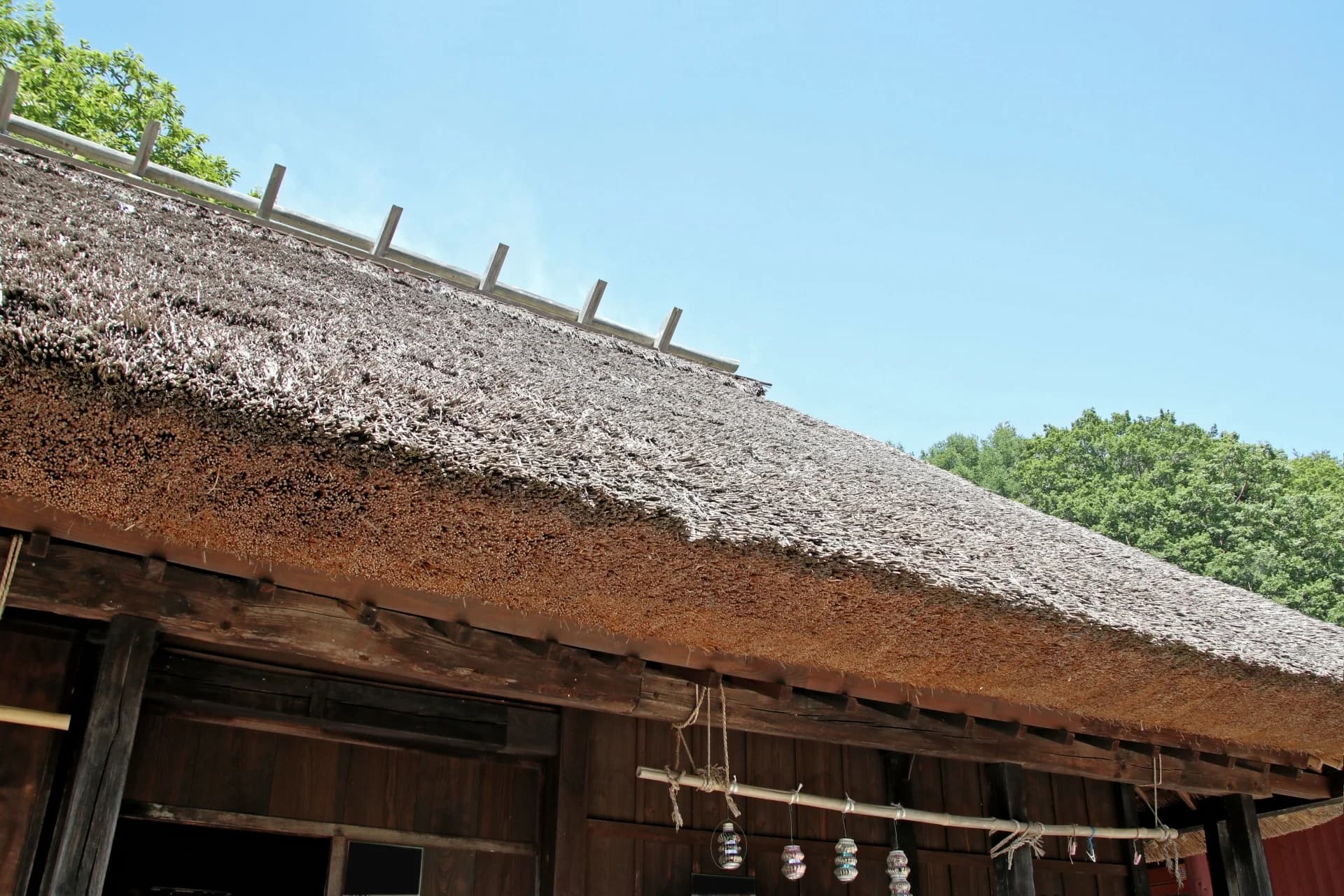 青空の下の茅葺き屋根と軒先