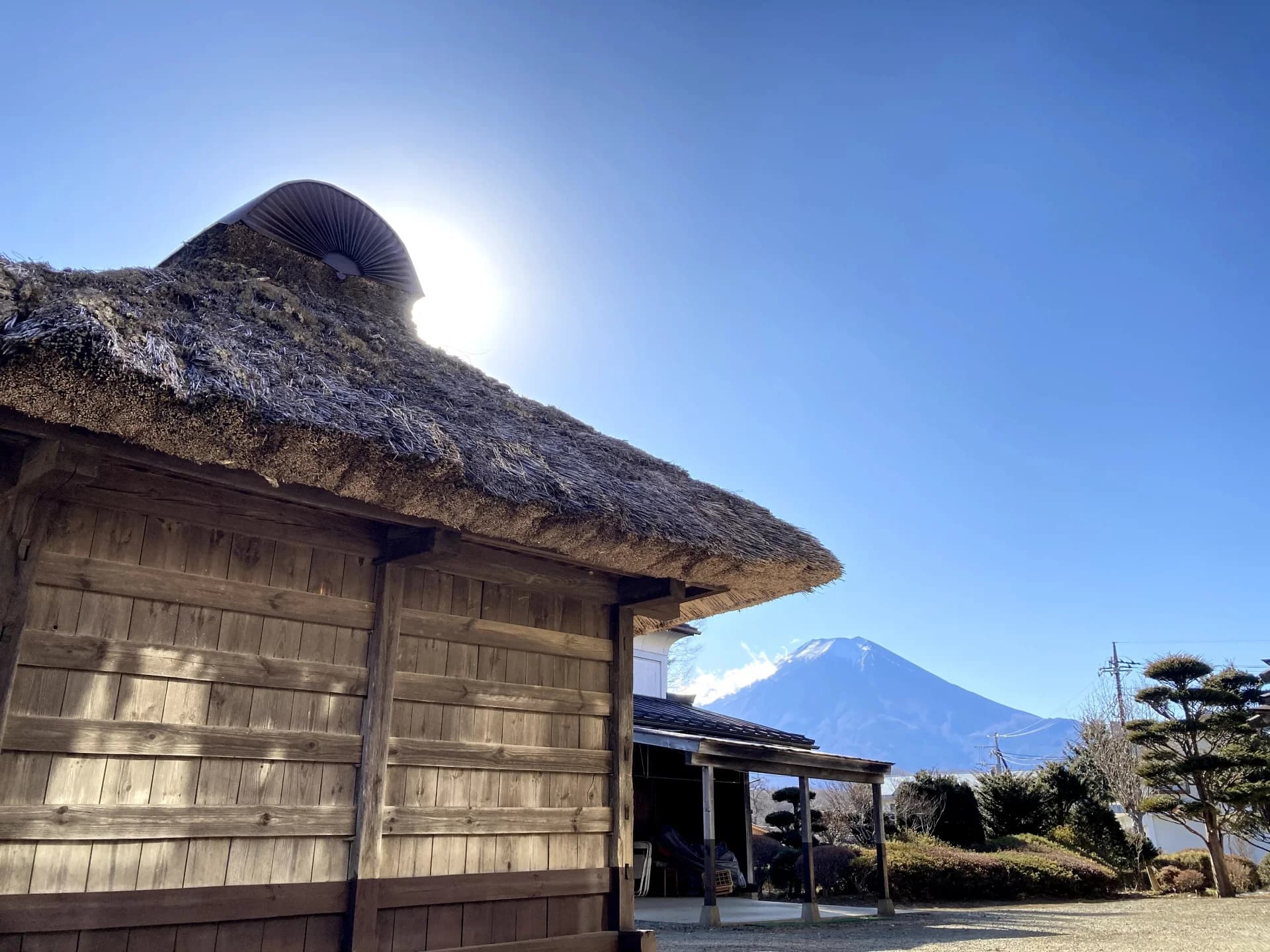 富士山を背にした忍野八海の茅葺き屋根の家（山梨県）