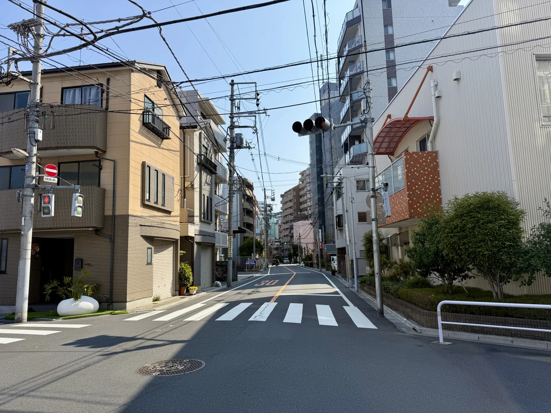 朝の東日暮里で3階建ての戸建てとマンションが並ぶ住宅街の通り（荒川区の空き家買取のイメージ）