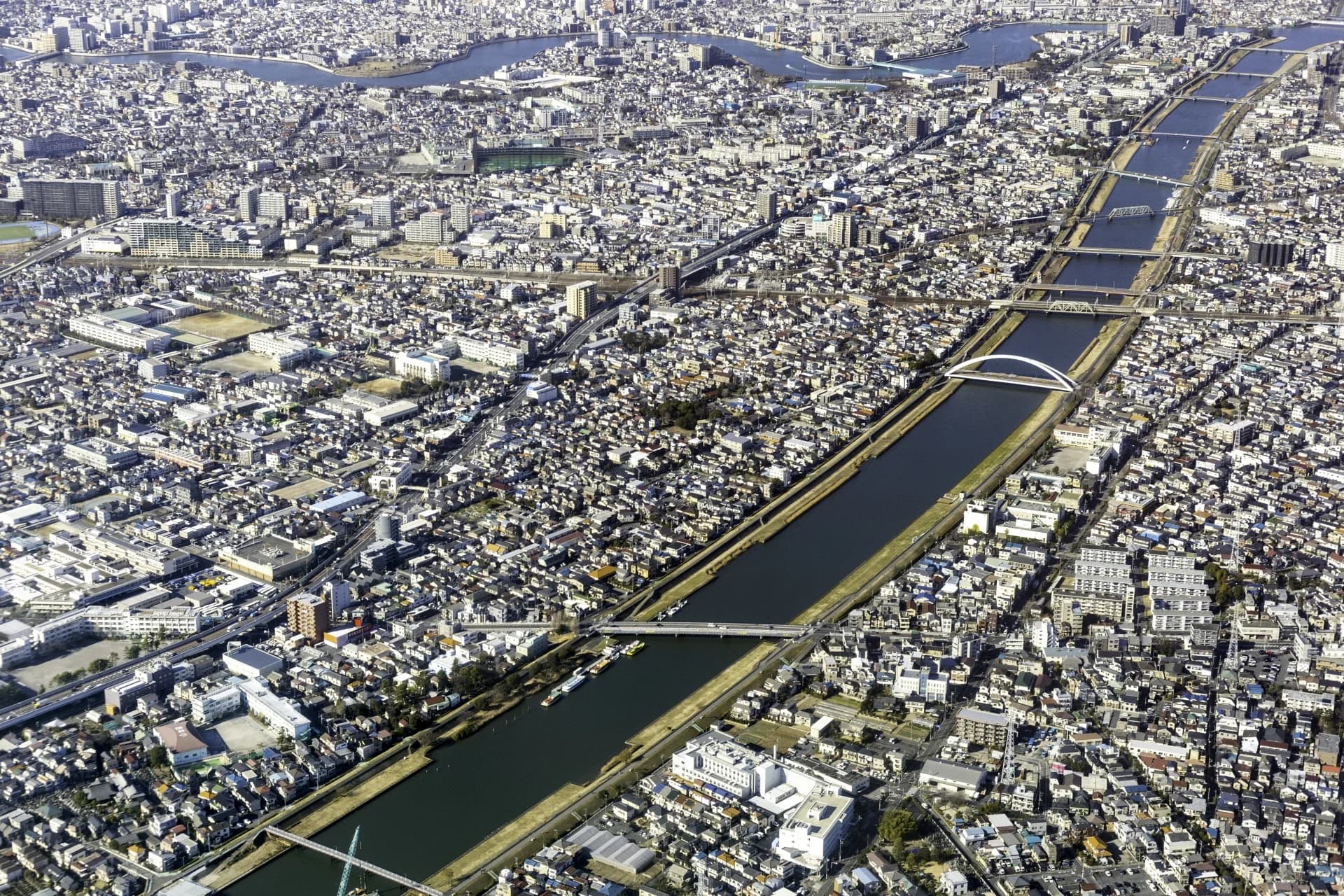 上空から見た江戸川区上一色付近の新中川沿いに住宅が密集する街並み（江戸川区の空き家買取のイメージ）