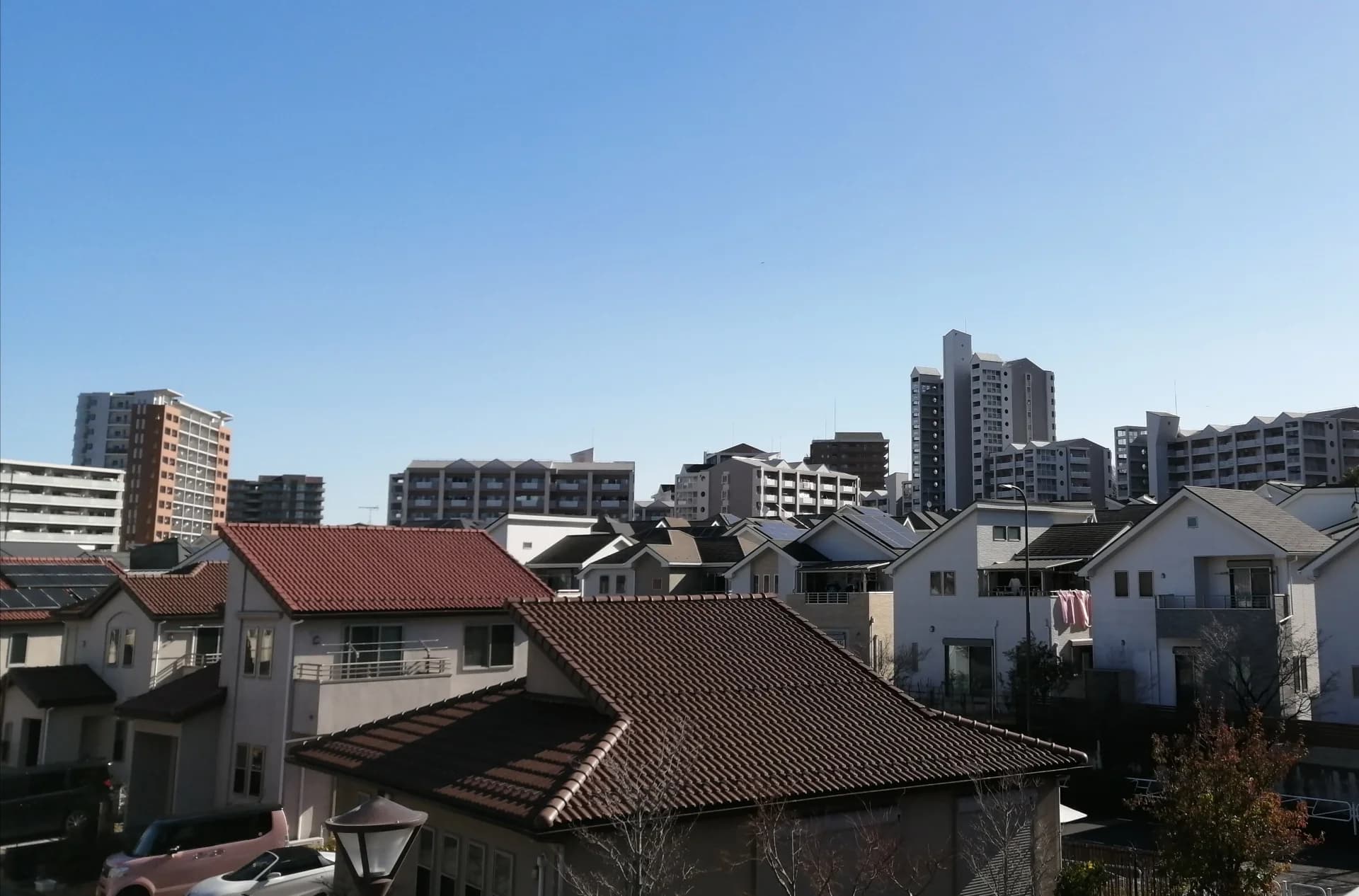 八王子市鑓水の戸建て住宅街と奥に建つ中高層マンション（八王子市の空き家買取のイメージ）