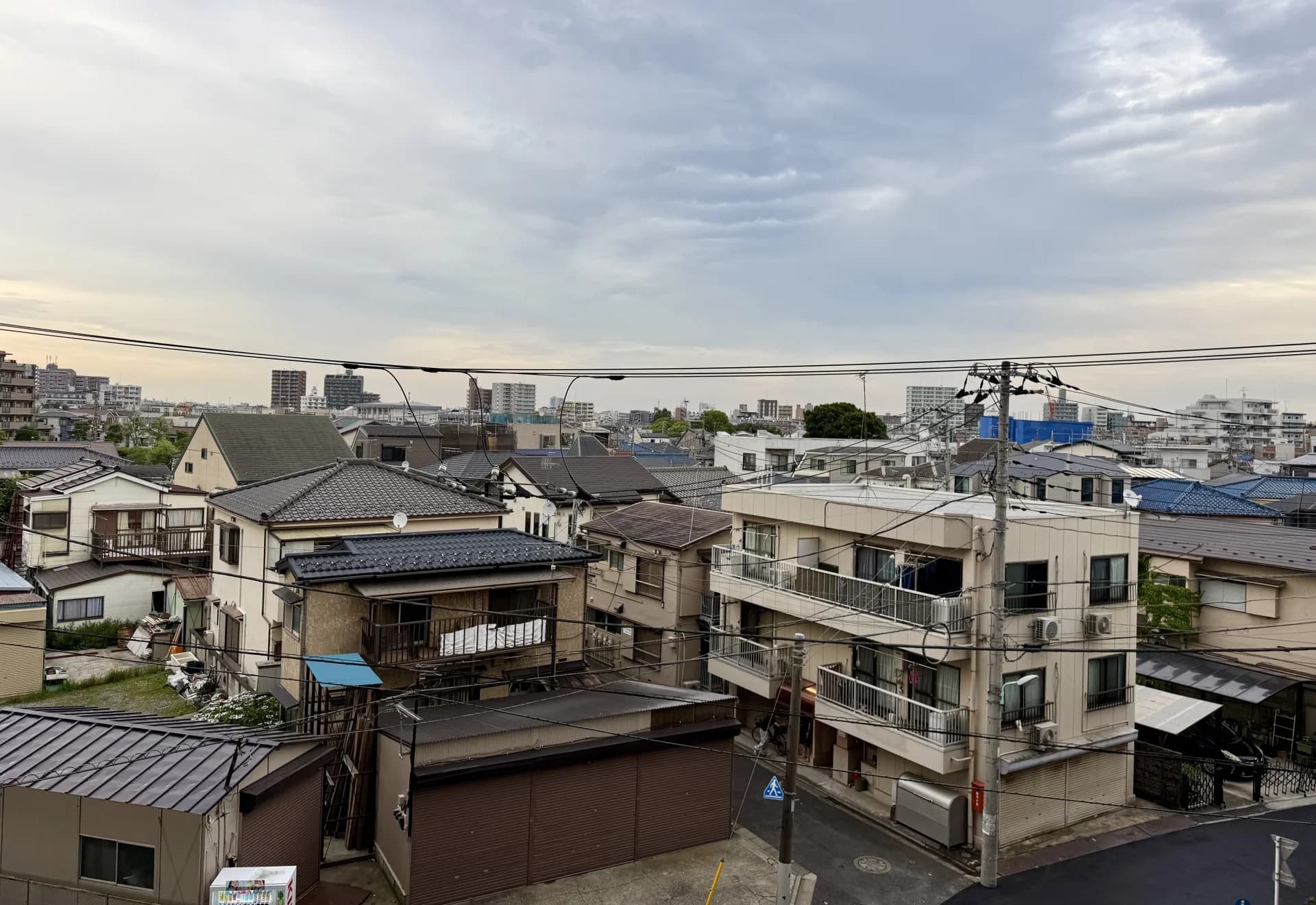 曇り空の堀切で瓦屋根の木造住宅と低層アパートが建て込む住宅街（葛飾区の空き家買取のイメージ）