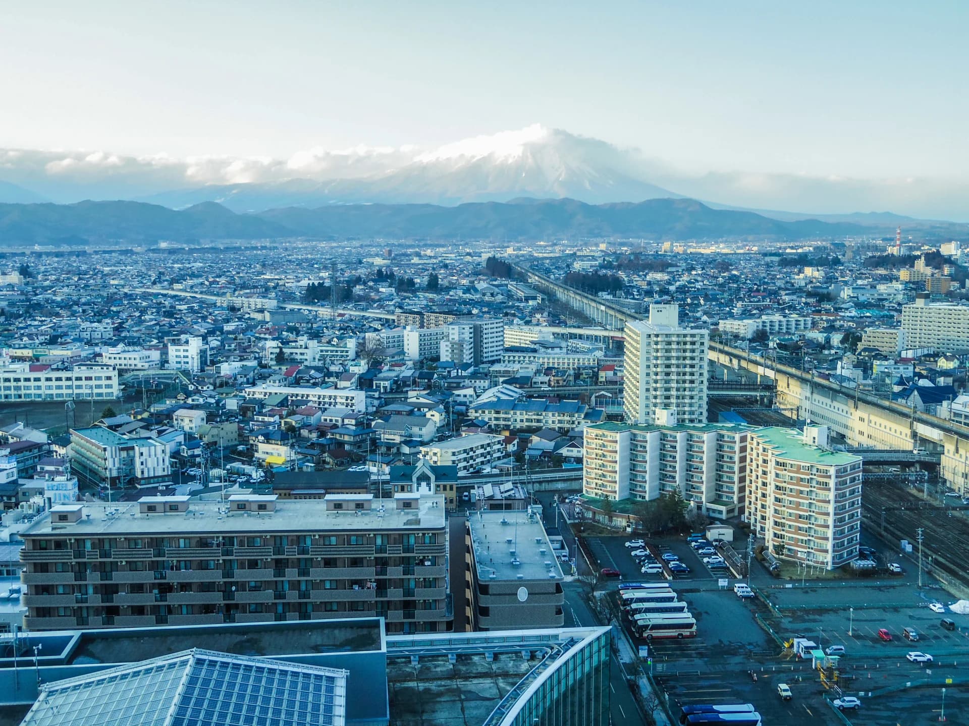 住宅やマンションが広がる盛岡市街と雪をかぶった岩手山（岩手の共有持分の買取のイメージ）