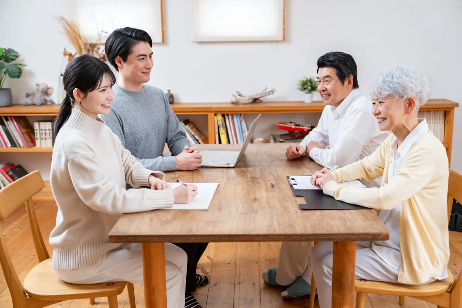 カップルとシニア夫婦が話し合う家族会議(相続・登記に関する記事のイメージ)