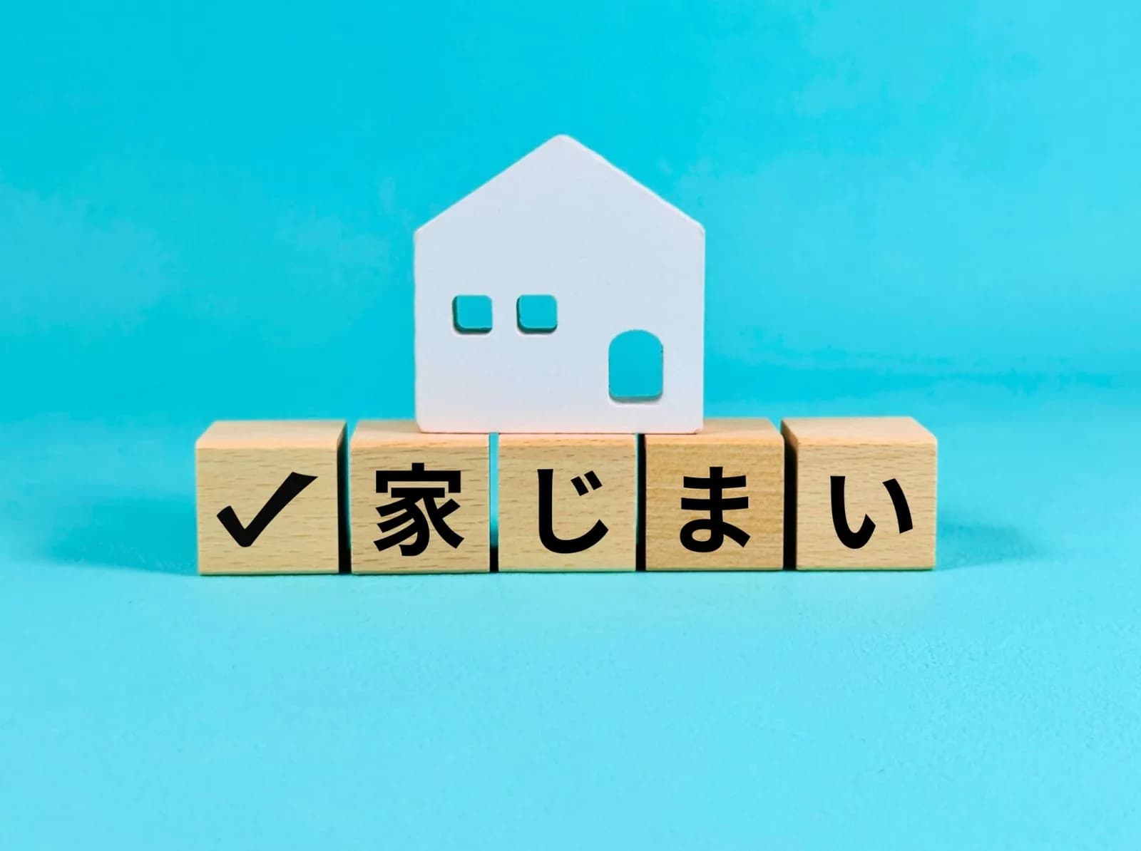 「家じまい」の文字ブロックと白い家の模型(家じまいに関する記事のイメージ)