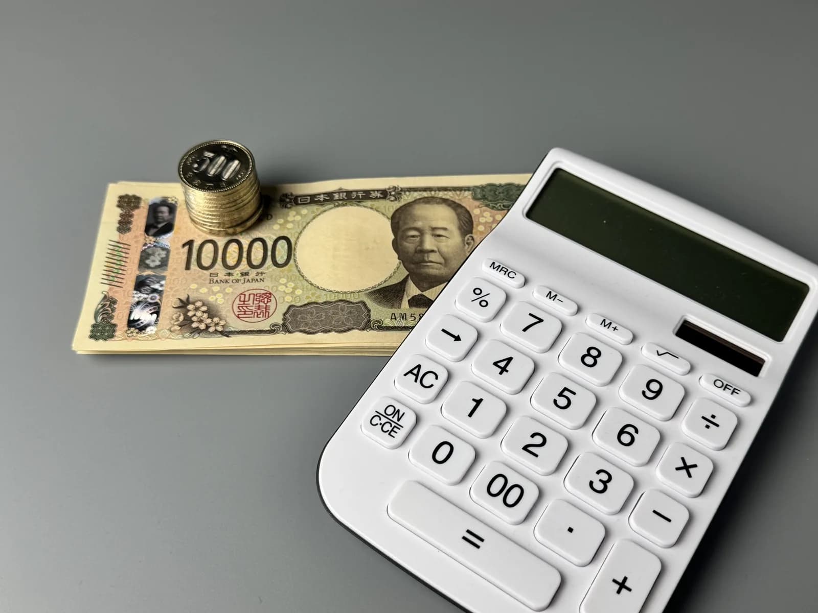 小銭とお札と電卓の家計管理のイメージ(不動産の税金に関する記事のイメージ)