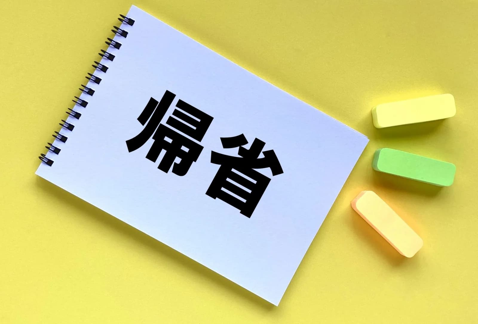 「帰省」と書かれたリングノートと付箋(遠方にある田舎の実家の処分に関する記事のイメージ)