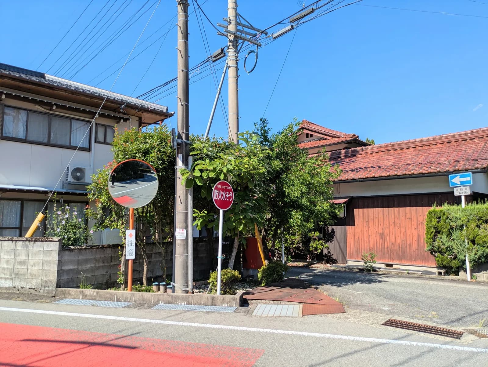 快晴の空に赤い家と道路と標識が映える街並(再建築不可・接道に関する記事のイメージ)
