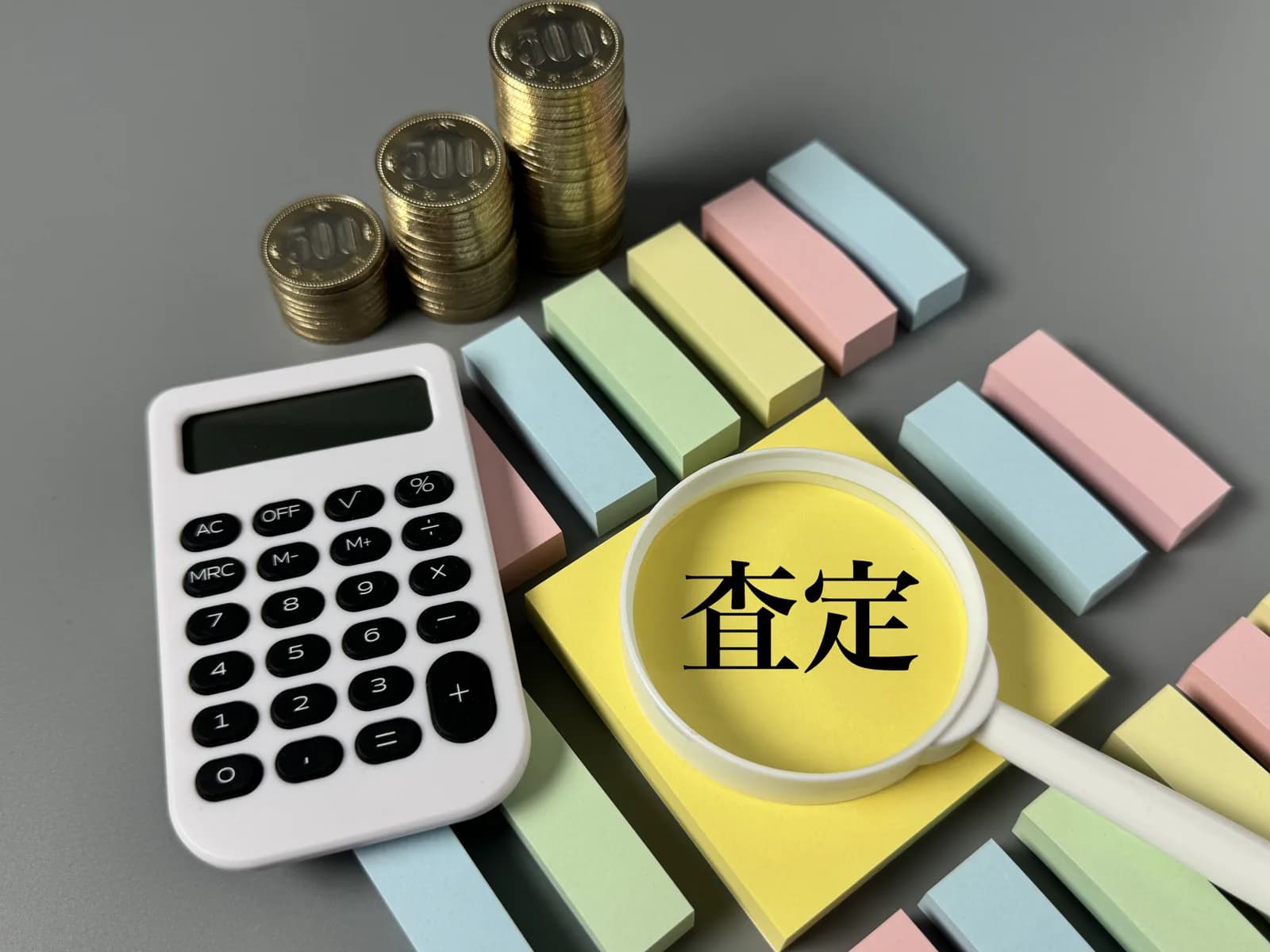 査定をイメージした現金と付箋と電卓(空き家に関する記事のイメージ)