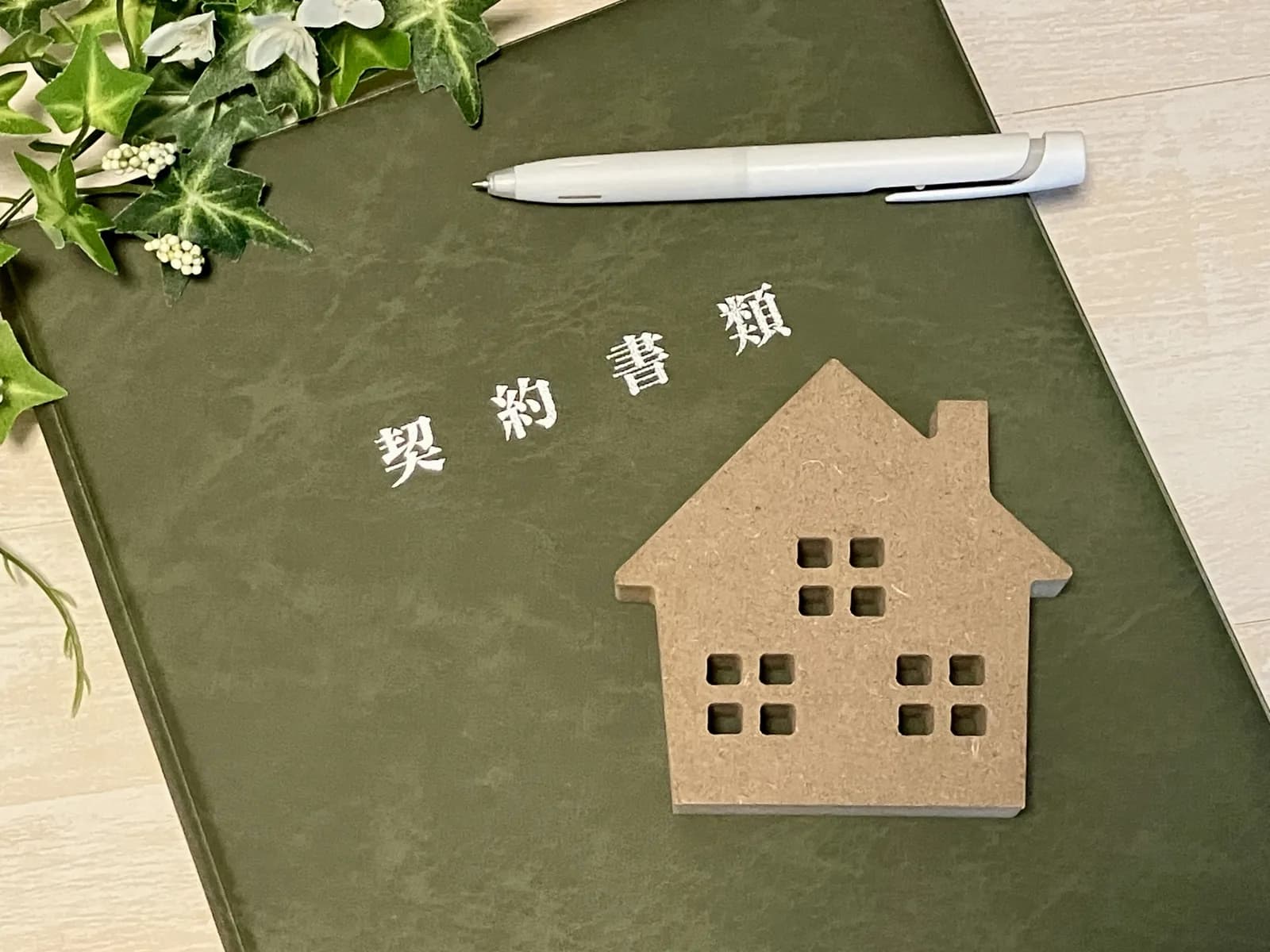 茶色い家のオブジェと契約書類(借地権・底地に関する記事のイメージ)