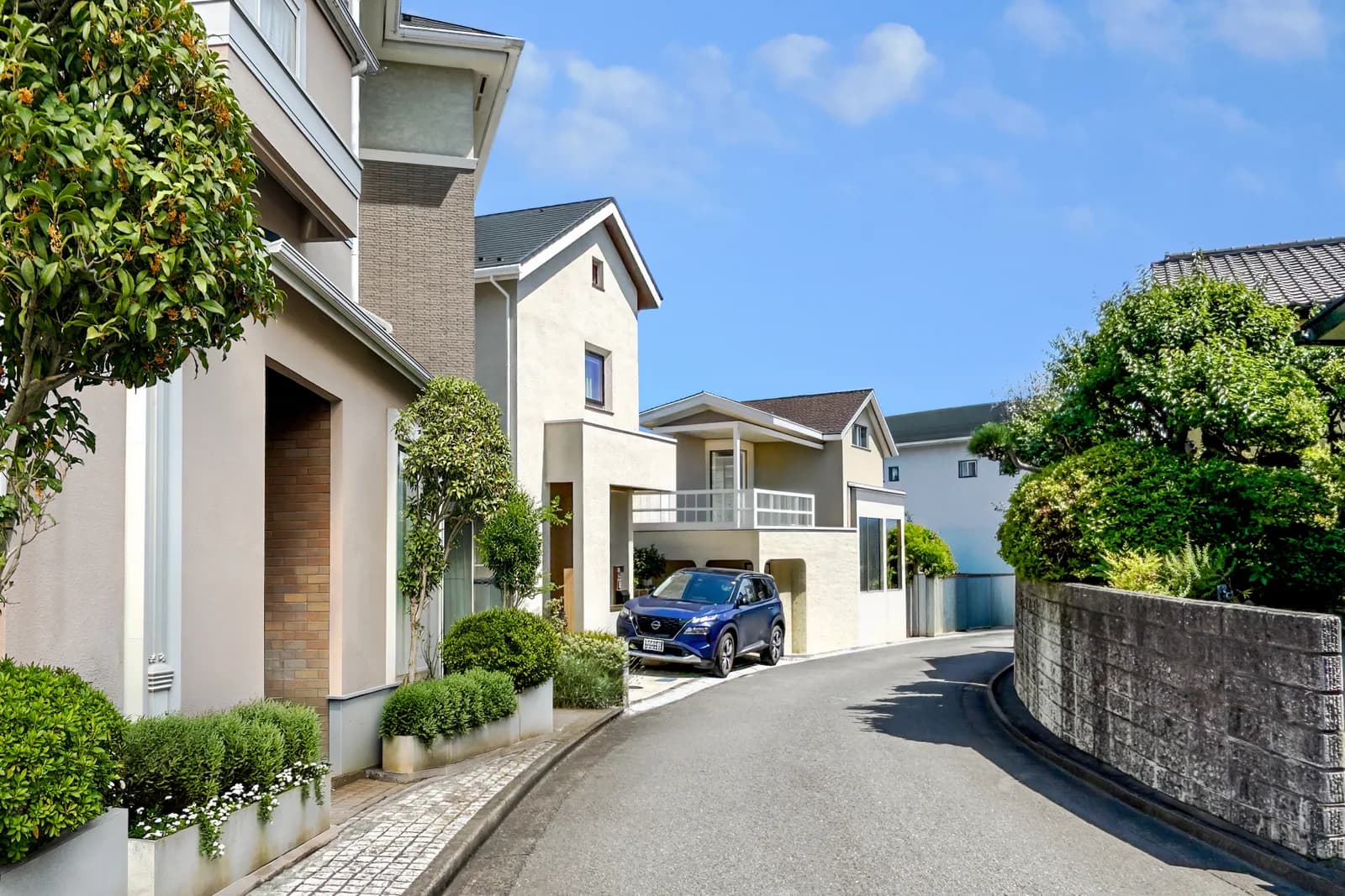 金木犀の木のあるカーブした道沿いの住宅街(借地権・底地に関する記事のイメージ)