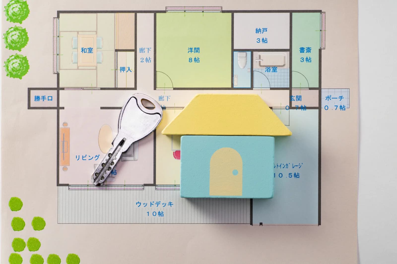 間取り図の上に置かれた積み木の家と鍵(空き家に関する記事のイメージ)