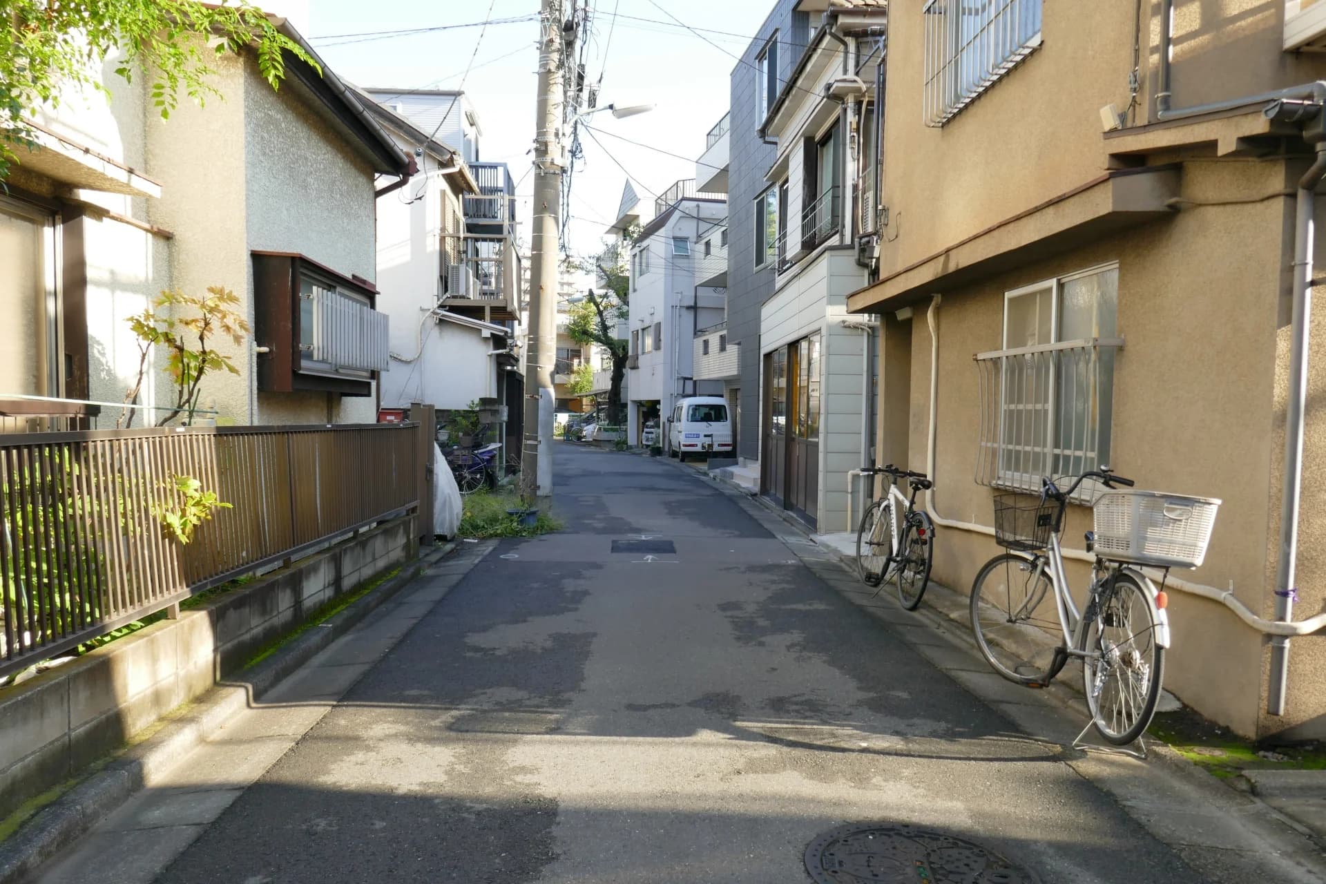 戸建てと低層住宅に挟まれた細い生活道路(品川区の空き家買取のイメージ)