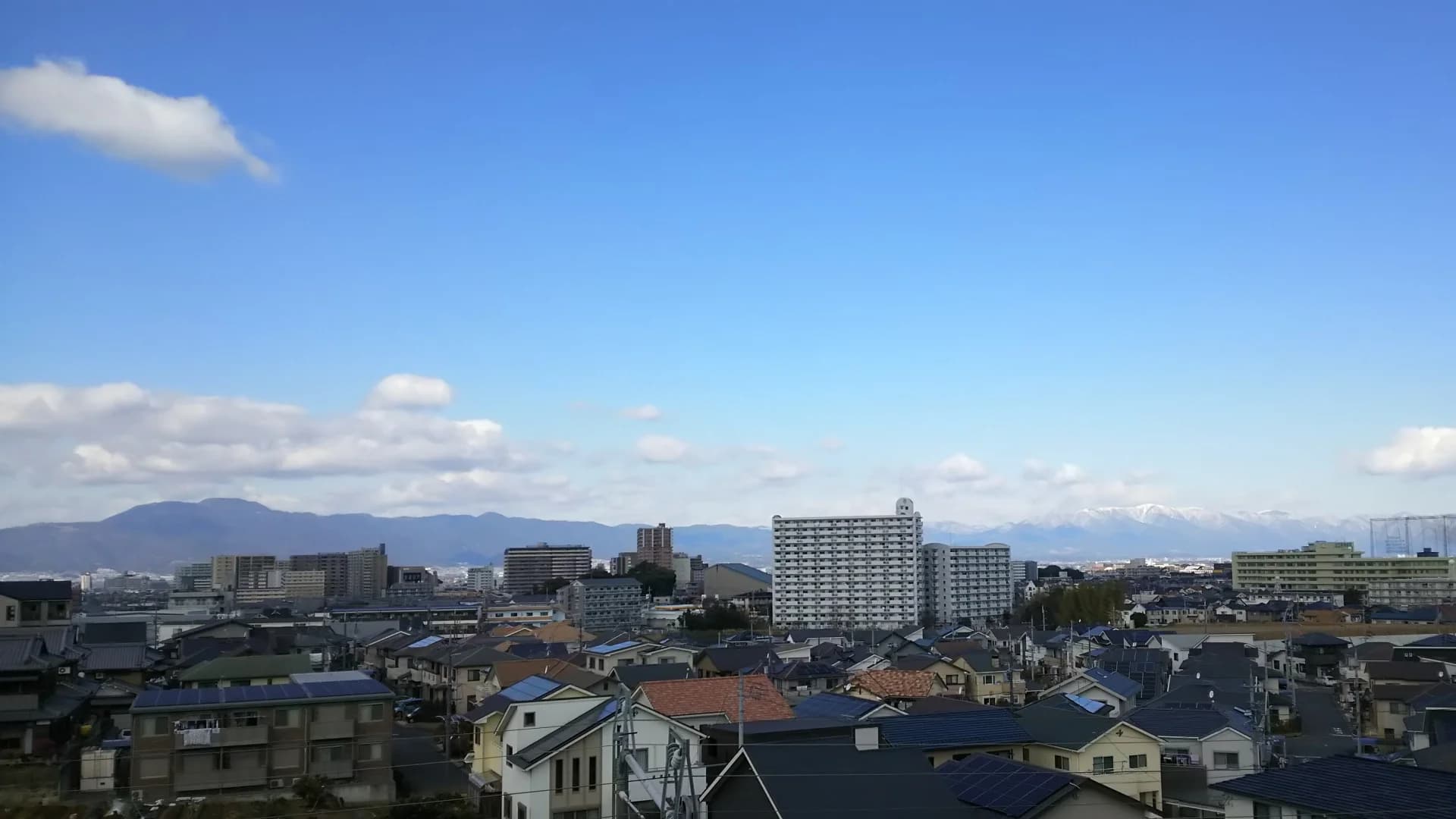 戸建て住宅とマンションが並ぶ南草津の住宅地と遠くの山並み(滋賀の共有持分の買取のイメージ)