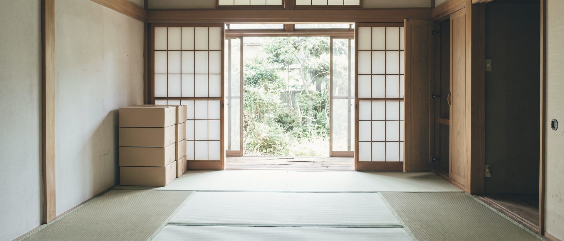 持ち主がいなくなった日本家屋の和室。畳の上に昼の光が差し、開けた障子の先に縁側と庭が見える