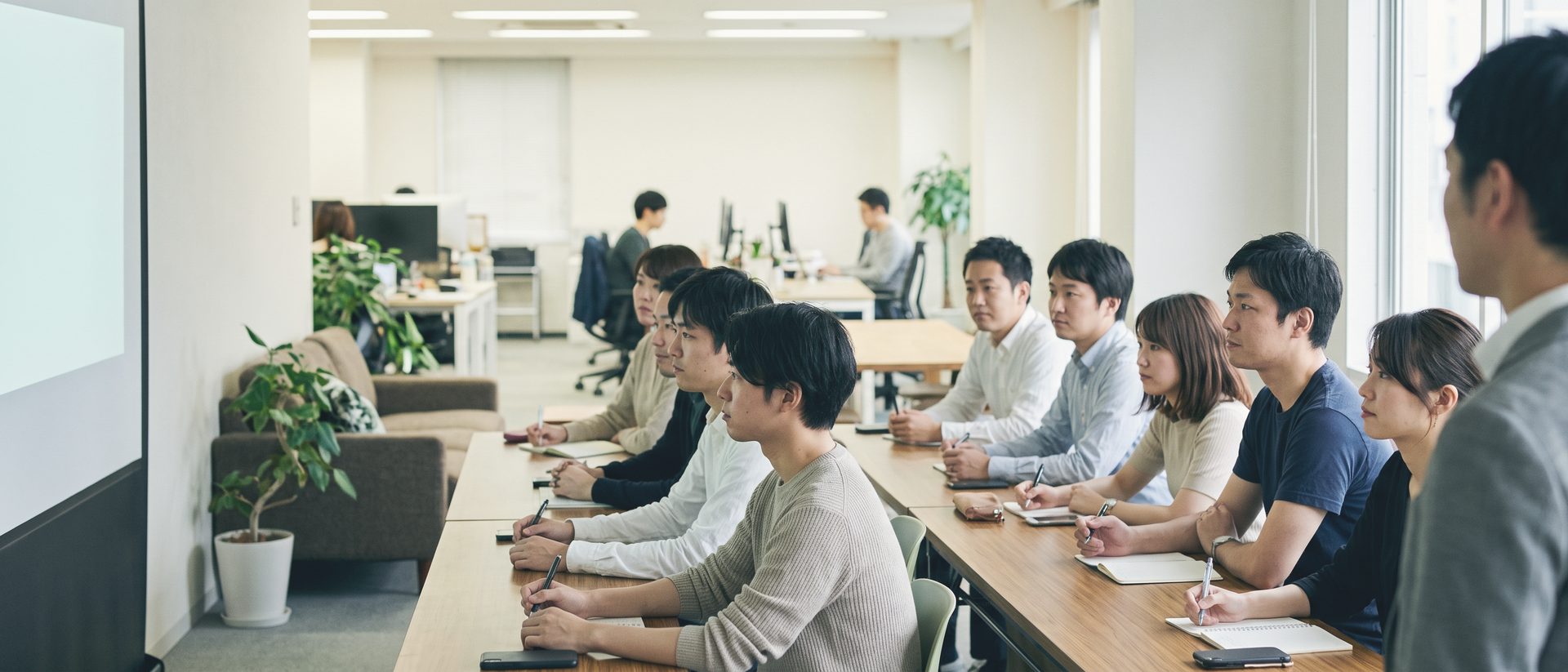 小さなセミナー室で、長机に並んだ10人ほどがペンを手に、前の白い投影面のほうを向いている
