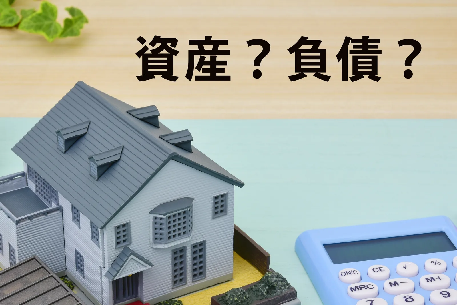 家の模型と電卓と「資産?負債?」の文字(負動産に関する記事のイメージ)