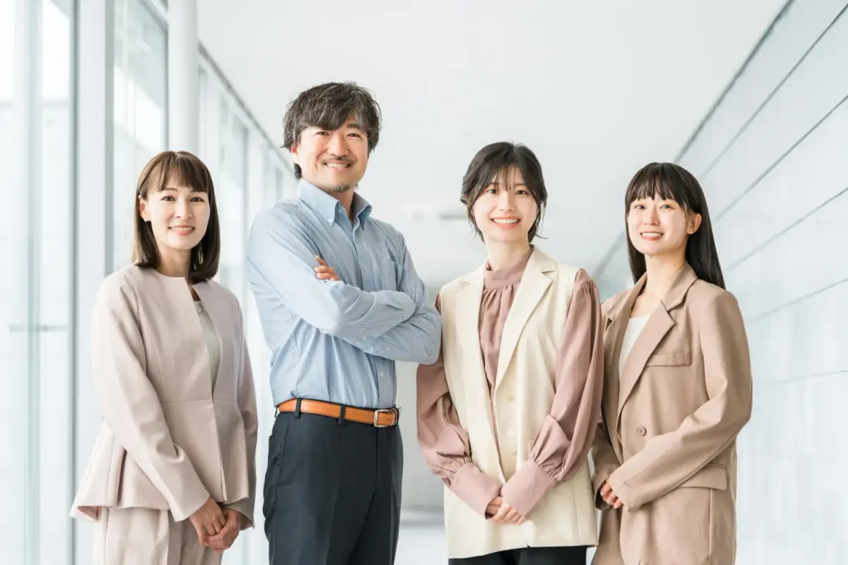 オフィスビルの廊下に並ぶビジネスマン（不動産買取業者に関する記事のイメージ）