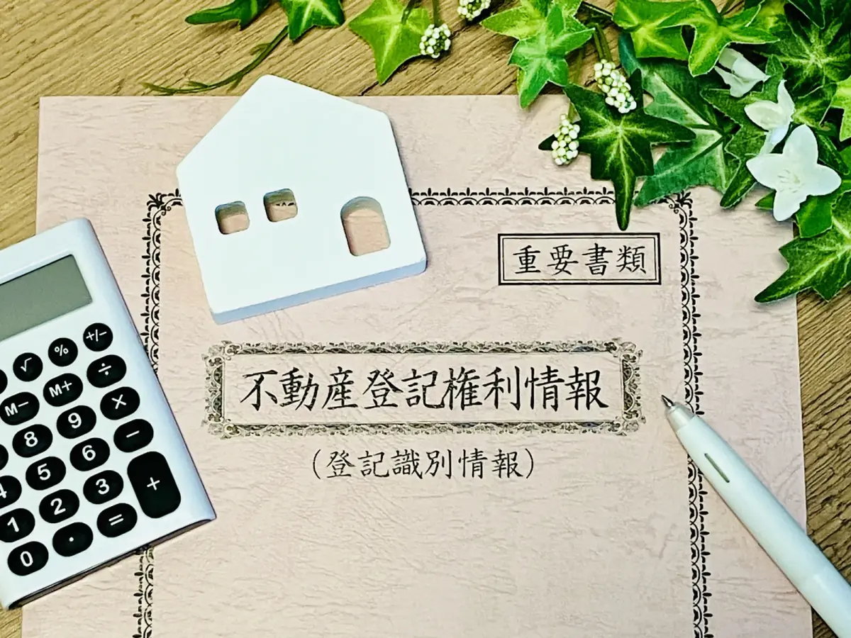 不動産登記(白い家のオブジェと電卓)(空き家に関する記事のイメージ)