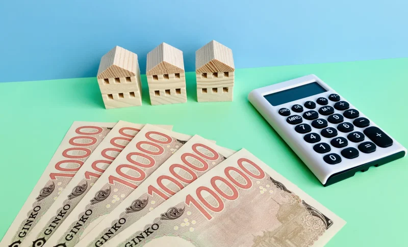 5万円と電卓と3軒の家（不動産の税金に関する記事のイメージ）