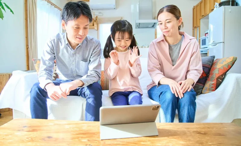 タブレットPCの画面を見る親子 （不動産売却に関する記事のイメージ）