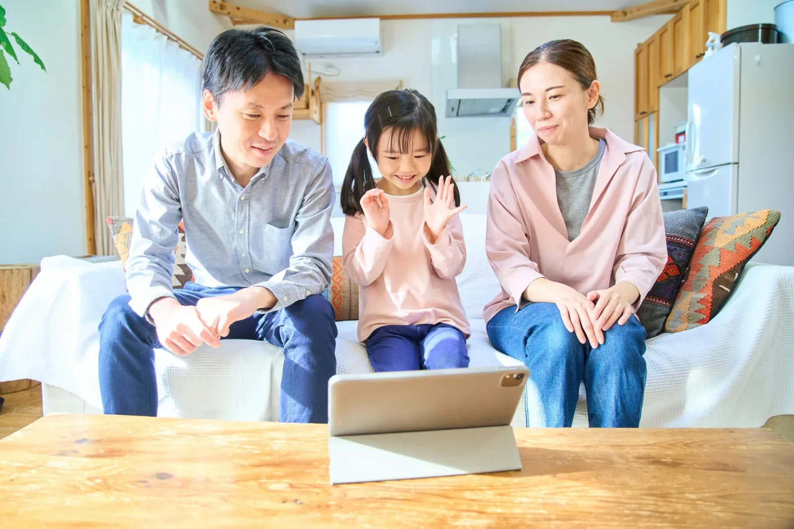 タブレットPCの画面を見る親子 (不動産売却に関する記事のイメージ)