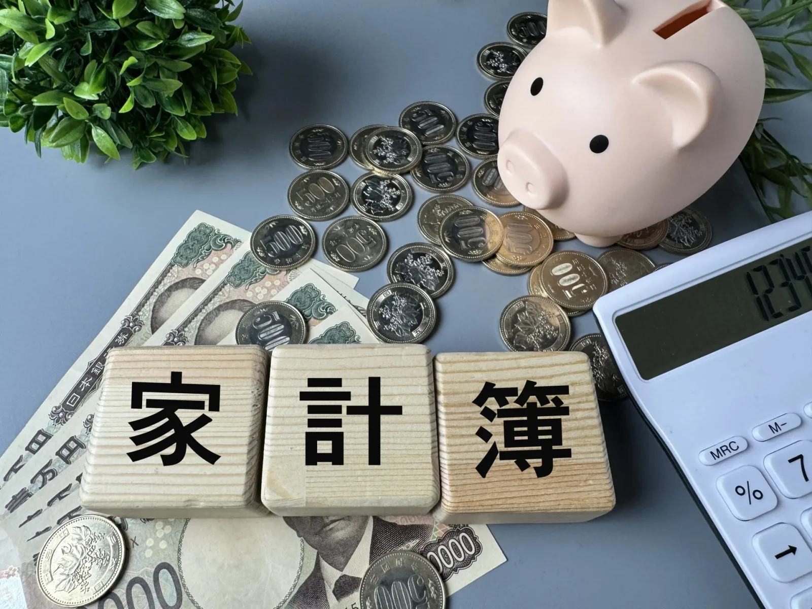 家計簿のイメージ|電卓と硬貨とお札(空き家に関する記事のイメージ)