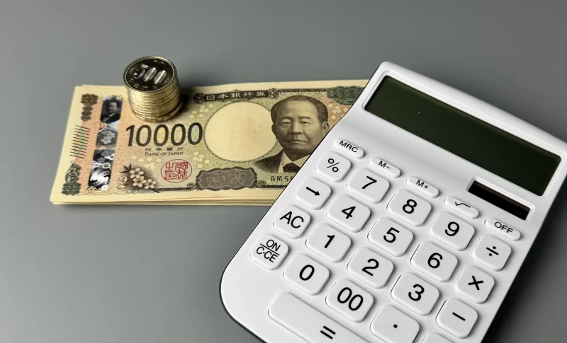 小銭とお札と電卓の家計管理のイメージ（不動産の税金に関する記事のイメージ）