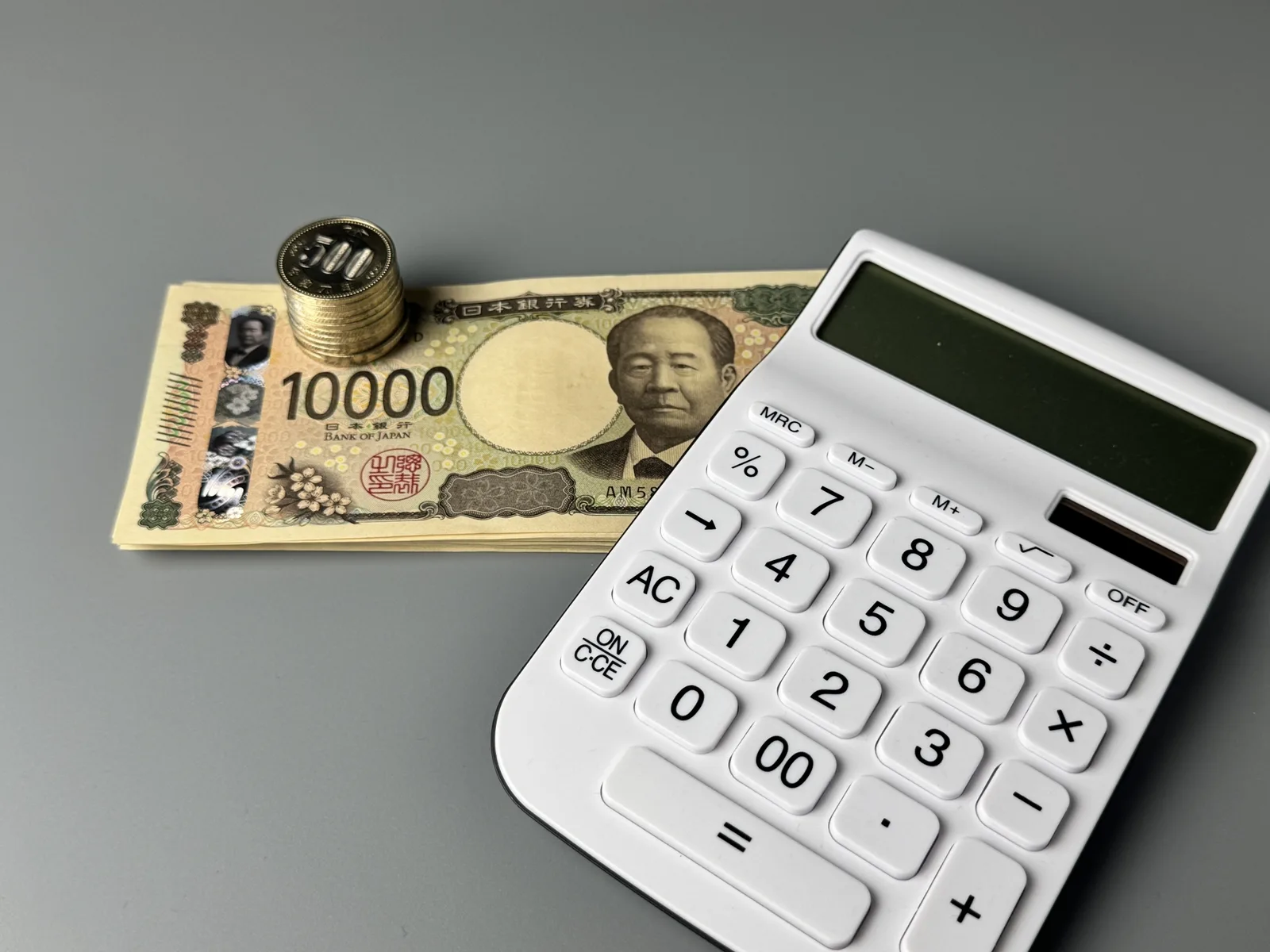 小銭とお札と電卓の家計管理のイメージ(不動産の税金に関する記事のイメージ)