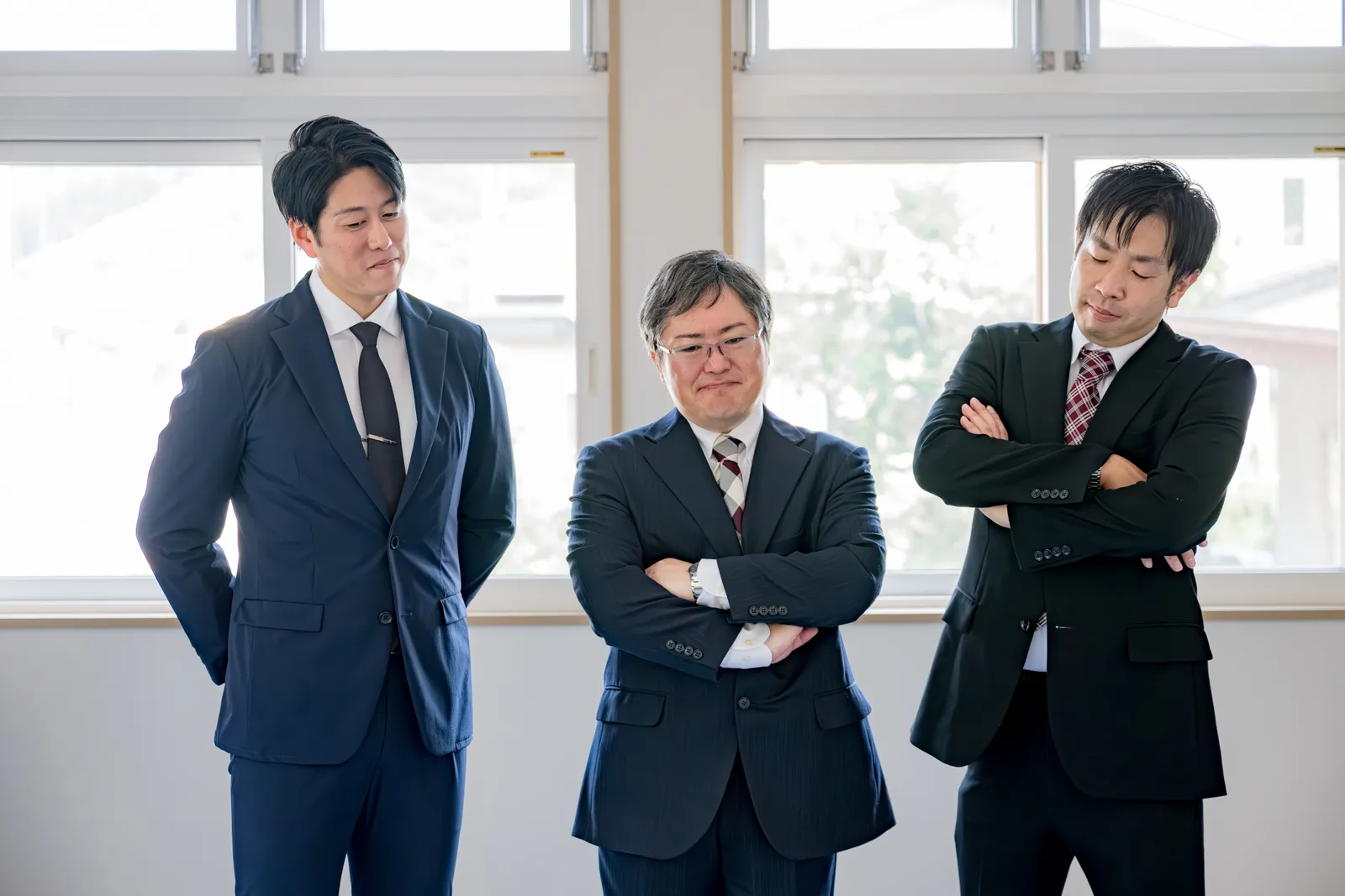 腕組みする3人のビジネスマン（不動産買取業者に関する記事のイメージ）
