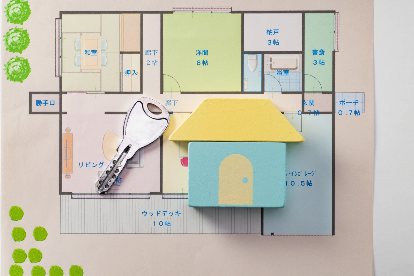 間取り図の上に置かれた積み木の家と鍵(空き家に関する記事のイメージ)
