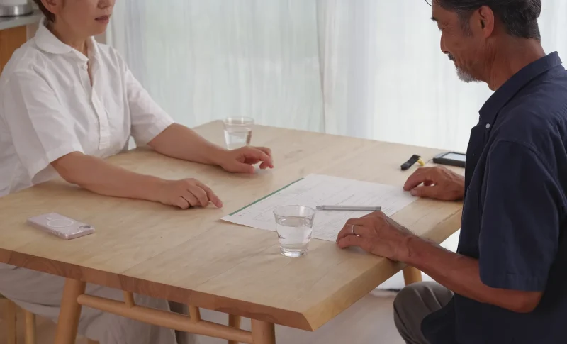 離婚届を見ながら話し合うシニア夫婦