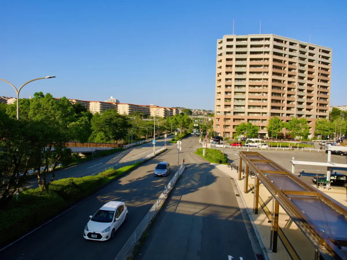青空が広がる都市の道路とマンション(事故物件に関する記事のイメージ)