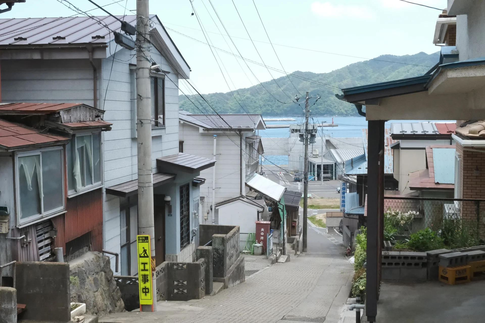 海へ下る細い坂道の両側に古い木造住宅が建ち並ぶ宮古市の路地(宮古市の0円物件のイメージ)