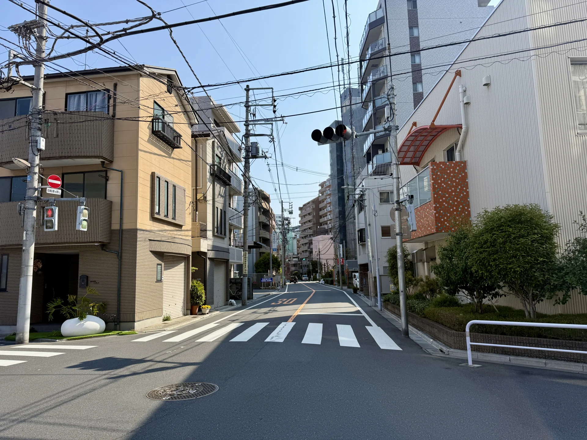 朝の東日暮里で3階建ての戸建てとマンションが並ぶ住宅街の通り(荒川区の空き家買取のイメージ)