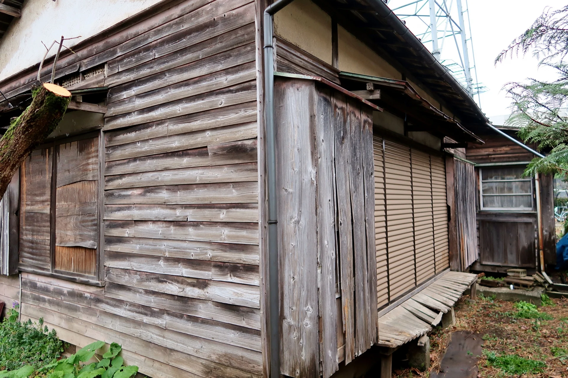 板張りの外壁が色あせた木造の古い家の側面(倉敷で空き家を無料で手放すイメージ)
