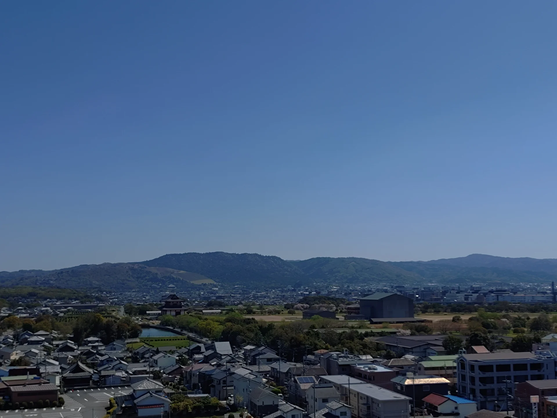戸建て住宅が手前に並び、奥に山並みが続く奈良市の街並み(奈良の共有持分の買取のイメージ)