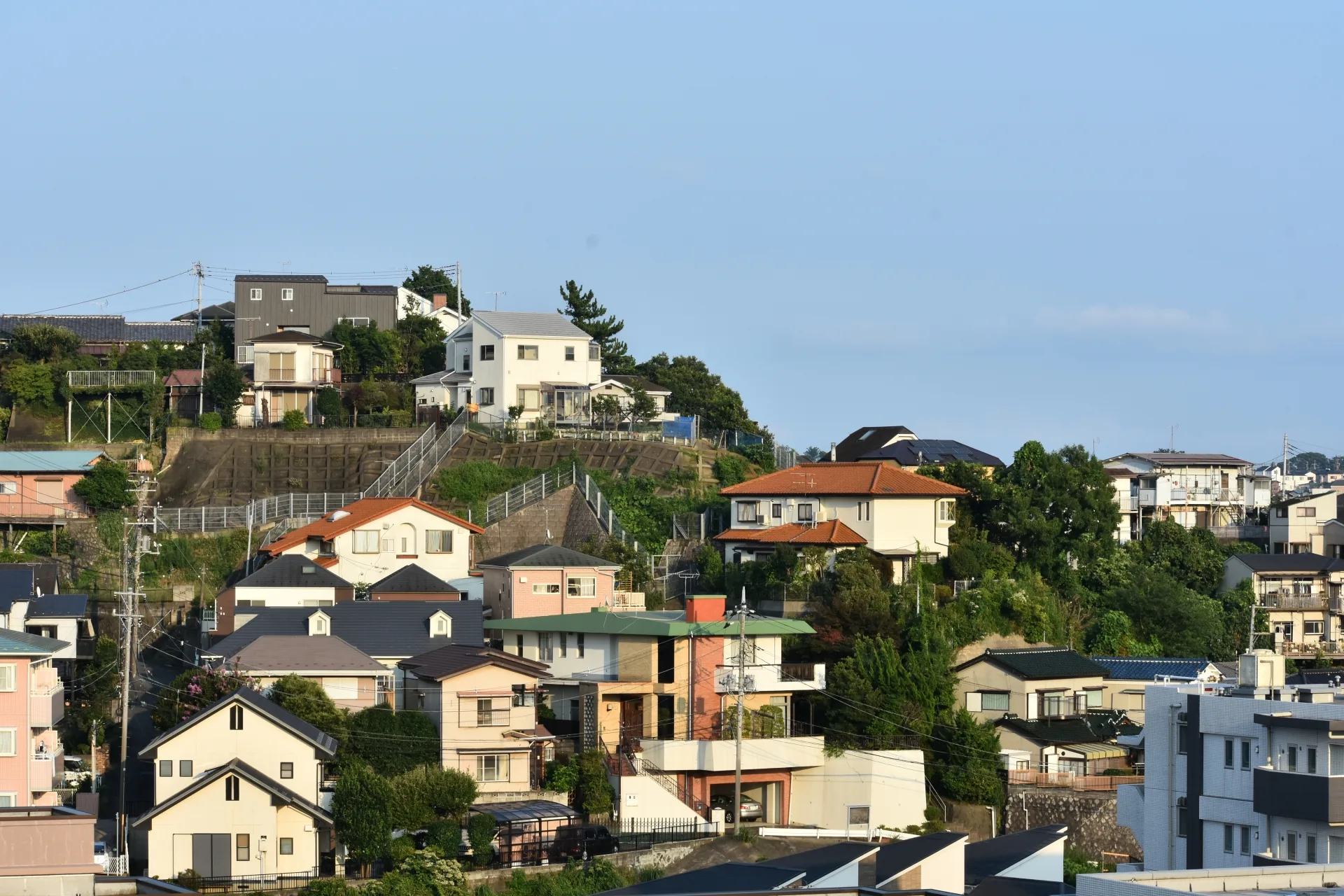 丘の斜面に戸建て住宅が建ち並ぶ横浜の住宅街(神奈川の事故物件の買取のイメージ)