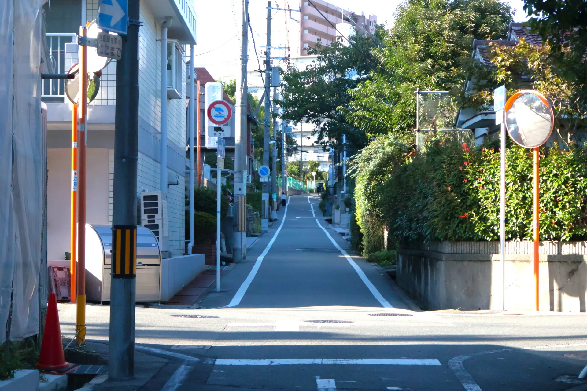 生垣と戸建て住宅・マンションが並ぶ大阪府吹田市の住宅地の通り(大阪の事故物件の買取のイメージ)