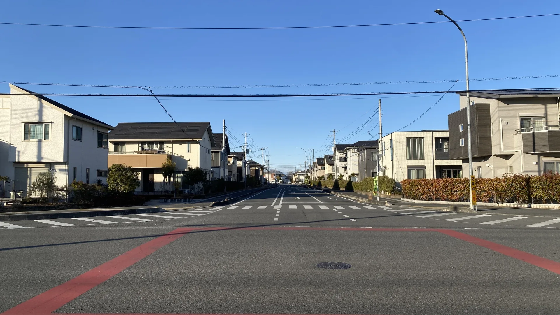 広い道路沿いに新しい戸建て住宅が並ぶ閑静な住宅街(埼玉の事故物件の買取のイメージ)