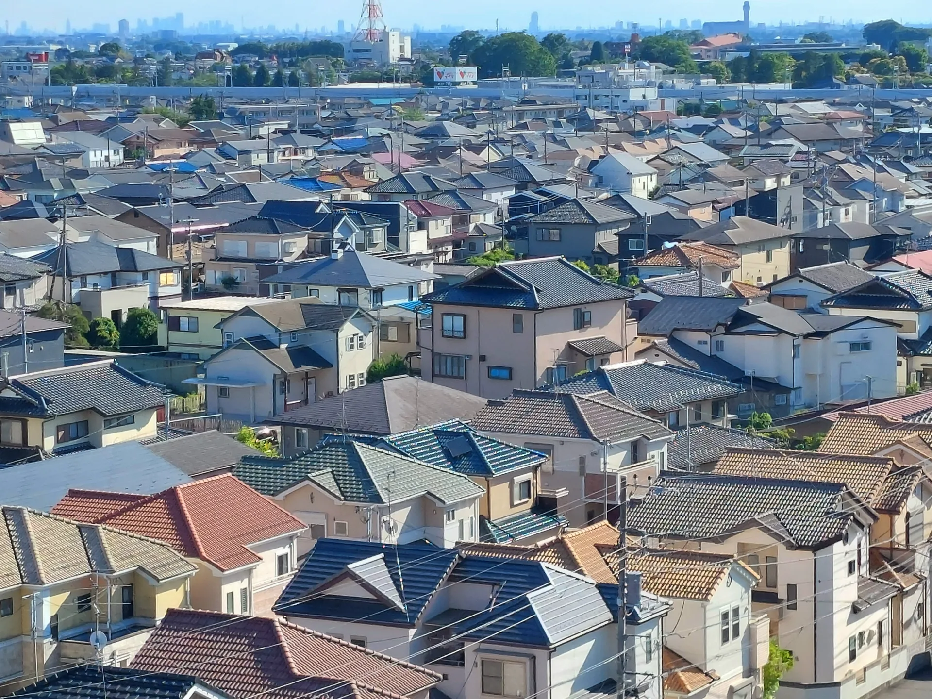 戸建て住宅の屋根が一面に並ぶ東京近郊の住宅街の俯瞰(東京の事故物件の買取のイメージ)